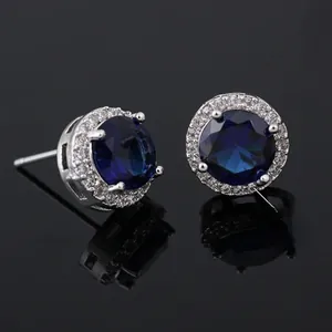 Detail view of round blue zircon stud earrings with claw setting and silver base