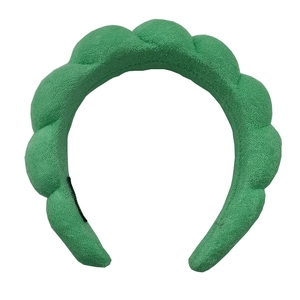 Detail of green padded sponge headband featuring a thick woven fabric texture