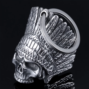 Close-up of a silver vintage Indian skull bell pendant with detailed feather headdress