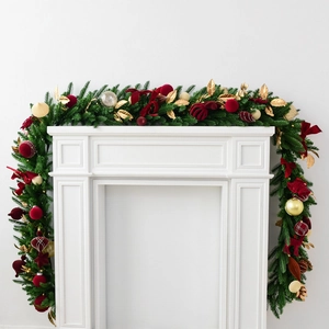 2.7m velvet ball Christmas garland with red bows and gold leaves on a white fireplace