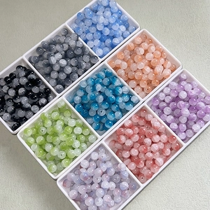 Macro shot of 10mm colorful round translucent glass beads in organized sorting trays