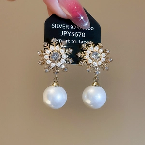 Detailed macro view of S925 silver snowflake earrings with zircon and white pearl drops