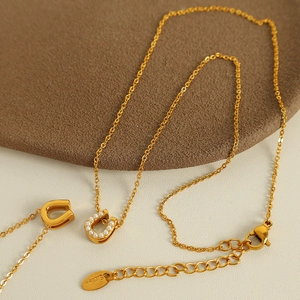 Collier avec pendentif fer à cheval doré en acier inoxydable et perles blanches élégantes