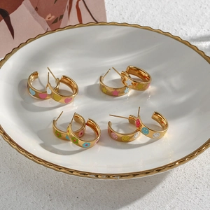 Detailed macro view of 18K gold plated hoop earrings with colorful enamel charms