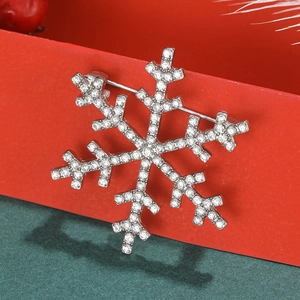 Close-up of snowflake brooch with inlaid rhinestones hanging on a festive red gift box