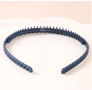 Close-up of matte navy blue headband with non-slip teeth and woven texture on a white tray