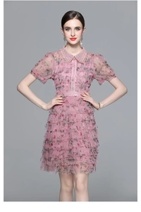 Détail de la robe rose en tulle avec col à paillettes et jupe à volants multicouche