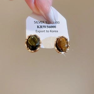 Macro shot of tiger eye stone earrings with S925 silver needles and golden metal frames