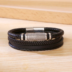 Close-up of men's multi-layer woven black leather bracelet with silver magnetic clasp