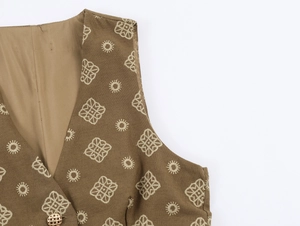 Détail d'un gilet ethnique marron avec broderie florale et bouton doré ajouré élégant
