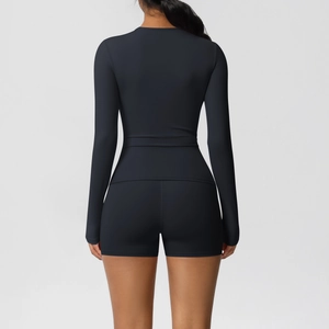 Back view of black yoga set with slim fit long sleeve top and high waist sports shorts