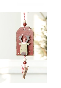 Détail d'un ornement de Noël en bois avec renne sur plaque rouge et perles