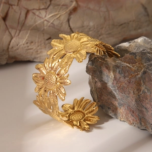 Dettaglio del bracciale a girasole dorato in acciaio inossidabile su una pietra naturale