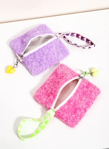 Detail of plush square coin purses in purple and rose with heart charms and wrist straps