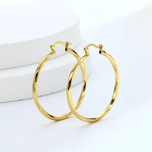 Detailed close-up of gold-plated S925 sterling silver hollow twisted hoop earrings