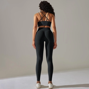 Detailed back view of black ribbed yoga set featuring cross-back bra and high-waist leggings