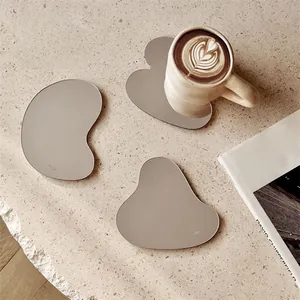Set di tre sottobicchieri irregolari in acrilico a specchio con tazza di caffè