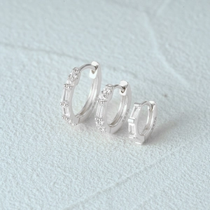 Macro shot of three S925 sterling silver hoop earrings with cubic zirconia in various sizes