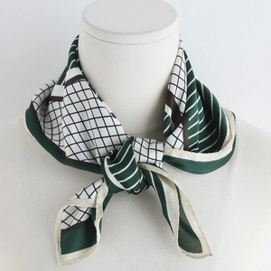 Detail of elegant silk scarf with green and black geometric patterns on a neck model