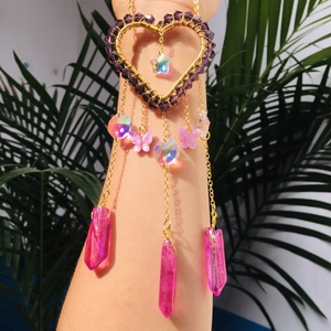 Detailed golden heart arm cuff with purple beads and pink crystal pendants shown on arm