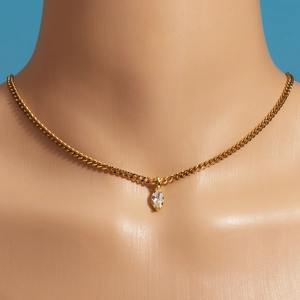Close-up of golden stainless steel chain with a marquise-cut zircon pendant on model