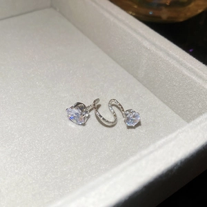 Detailed macro of silver spiral earrings with zircon stones in a jewelry box display