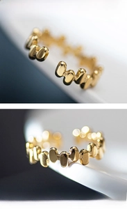 Macro shot of irregular geometric gold stainless steel ring with polished bean accents