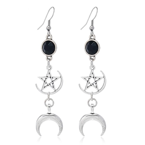 Détail de boucles d'oreilles gothiques vintage argentées avec lune, étoile et perles
