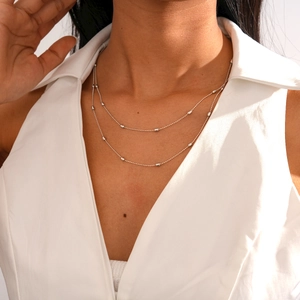 Detail of a silver beaded double-layer necklace on model with minimalist style