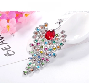 Detailed macro view of colorful rhinestone peacock brooch with red teardrop gem