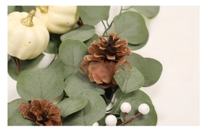 Detail of autumn wreath with white pumpkins, pinecones, berries and eucalyptus leaves