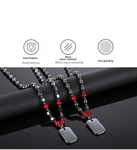 Detail view of hematite beads with military style dog tags and polished red stone accents