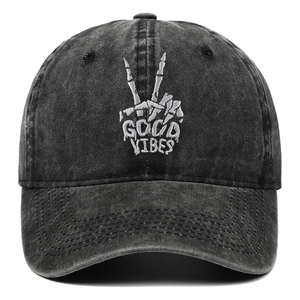 Macro view of white skeleton hand embroidery and Good Vibes text on washed black cotton cap