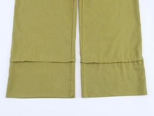 Detail of olive green linen trousers leg showing double-layered stitched hem texture