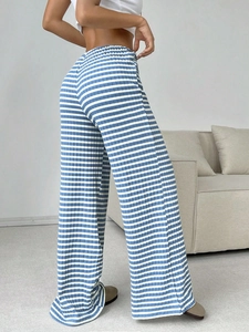 Detail of high waisted wide leg knit trousers featuring blue and white horizontal stripes
