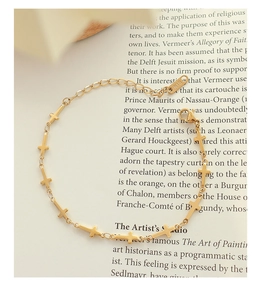 Detail of 18K gold plated cross bracelet showing lobster clasp and K18 hallmark stamp