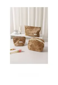 Detailed set of three khaki cotton makeup bags with elegant floral embroidery and zippers