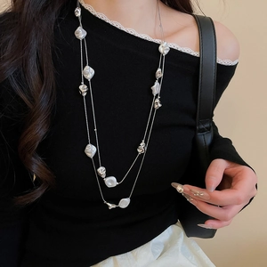 Close-up of double-layer vintage necklace with crystal beads and pearls on a model