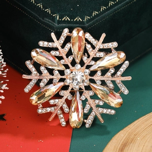 Detailed view of a golden snowflake brooch with sparkling crystals on festive velvet