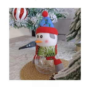 Side view of a cute snowman Christmas candy jar with blue hat and green scarf decor