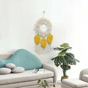 Bohemian woven tapestry with white cotton tassels and yellow leaf accents on a wall