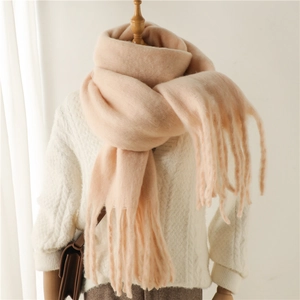 Détail d'une écharpe chaude en mohair abricot avec texture épaisse et longues franges