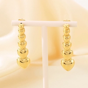 Polished 18k gold stainless steel heart drop earrings on a premium display stand