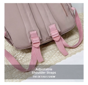 Detail of adjustable padded shoulder straps on a pink waterproof school backpack