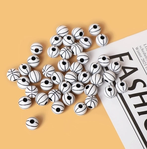 Macro shot of white basketball-shaped acrylic beads with black lines for DIY jewelry