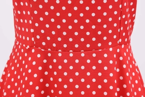 Detail of waist stitching on a red polka dot dress with premium plain weave texture