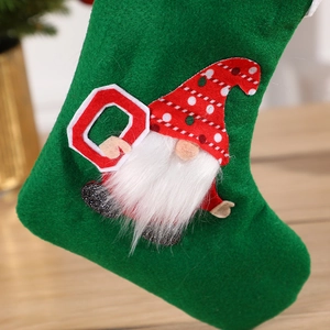 Chaussette de Noël en feutre vert avec gnome en peluche tenant une lettre O rouge