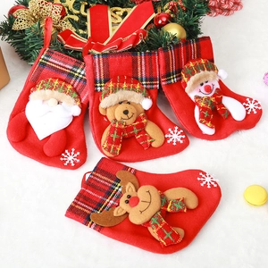 Detail of four red felt Christmas stockings with festive cartoon character appliques