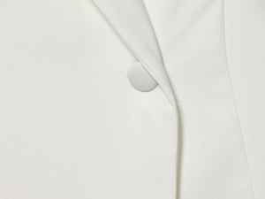 Close-up of white blazer with twill fabric texture and matching fabric-covered buttons