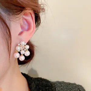 Vintage style gold-plated square zircon and pink pearl tassel earrings worn by a model